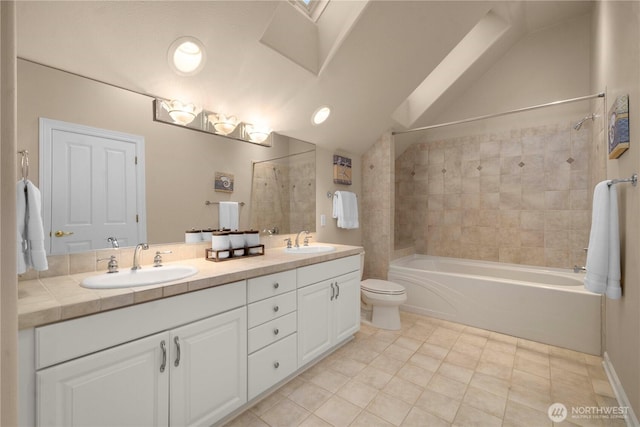 bathroom with vaulted ceiling, toilet, shower / bathtub combination, and a sink