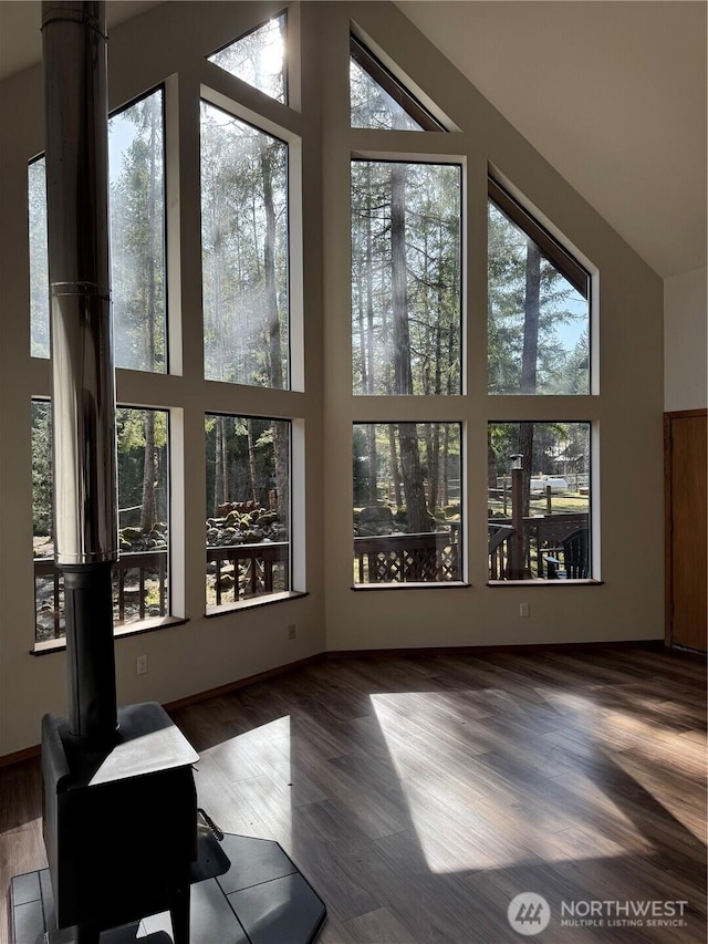 living room with wood finished floors, a healthy amount of sunlight, and high vaulted ceiling