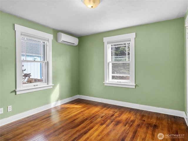 empty room with baseboards, a wall unit AC, and dark wood-style flooring