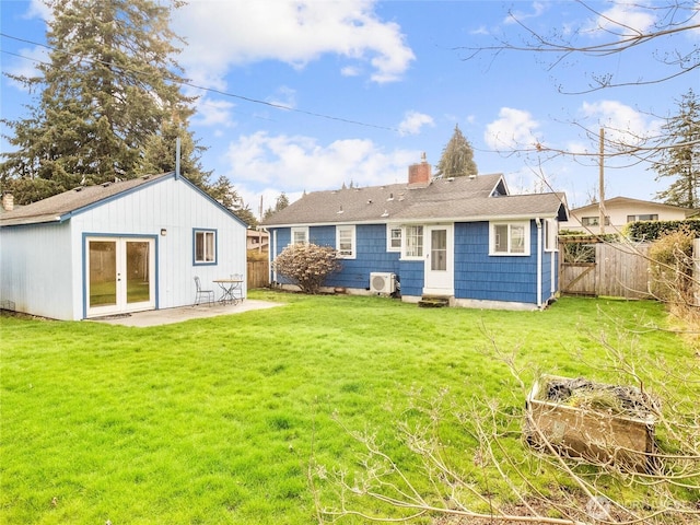 rear view of property with fence, a chimney, french doors, a patio area, and a lawn