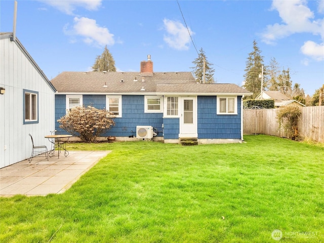 rear view of house with a patio area, a lawn, a fenced backyard, and a chimney