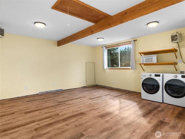 clothes washing area featuring washing machine and clothes dryer, laundry area, attic access, and wood finished floors