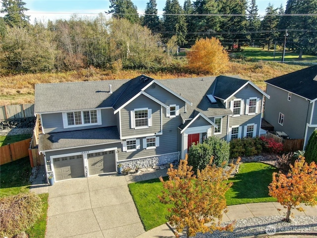 view of front of house with a front lawn, an attached garage, fence, and driveway