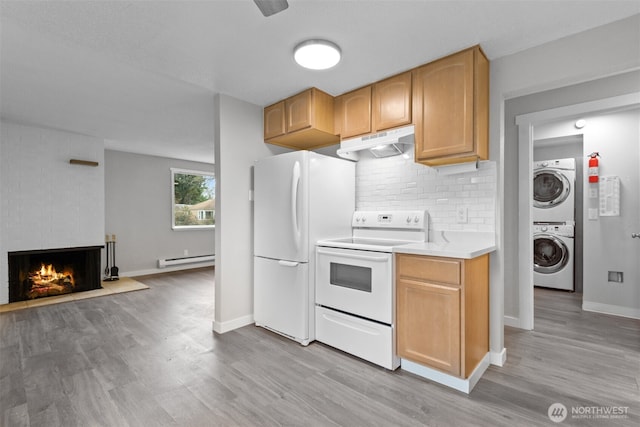 kitchen with backsplash, a baseboard heating unit, under cabinet range hood, stacked washer and dryer, and white appliances