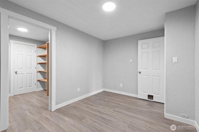 unfurnished room with baseboards and wood finished floors