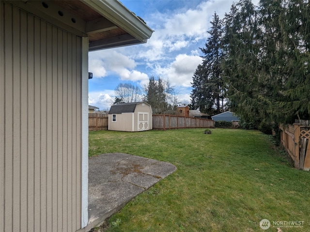 view of yard with an outbuilding, a storage unit, and a fenced backyard