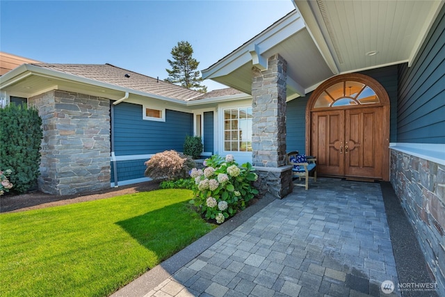 5685 Nakat Way, Blaine, WA 98230 - view of exterior entry featuring stone siding, roof with shingles, and a yard