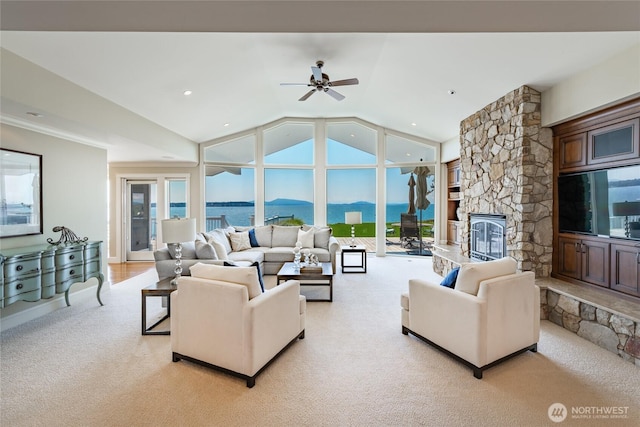 5685 Nakat Way, Blaine, WA 98230 - living room with light colored carpet, a stone fireplace, healthy amount of natural light, vaulted ceiling, and a ceiling fan