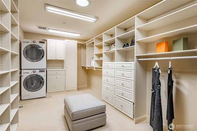 5685 Nakat Way, Blaine, WA 98230 - laundry area with stacked washer and clothes dryer, cabinet space, light carpet, and baseboards