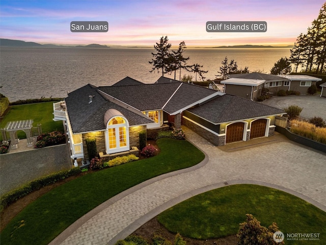 5685 Nakat Way, Blaine, WA 98230 - view of front of property featuring curved driveway, a garage, a water view, and stone siding