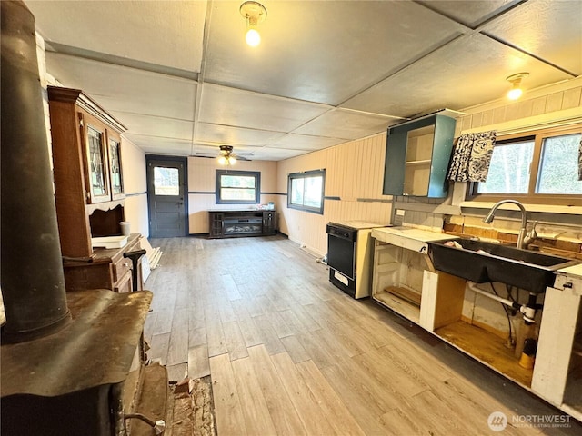 kitchen featuring a sink, light countertops, light wood-style flooring, a ceiling fan, and open shelves