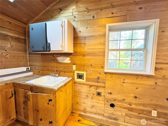 interior space with wooden walls, wood ceiling, washer hookup, laundry area, and a sink