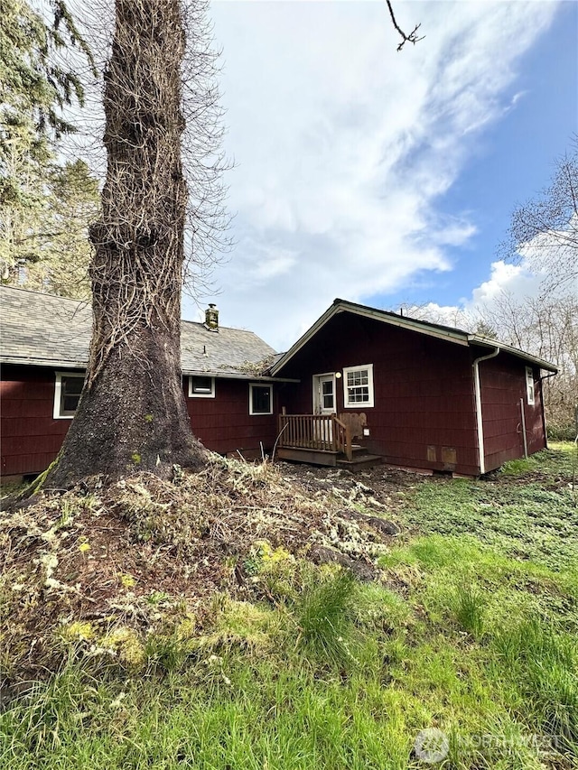 rear view of property featuring a deck and a chimney