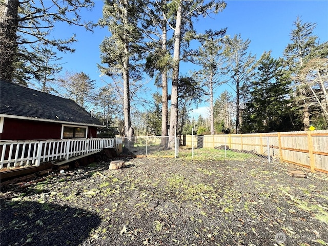 view of yard with a wooden deck and a fenced backyard