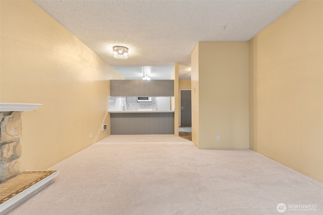 interior space with visible vents, a textured ceiling, and carpet floors