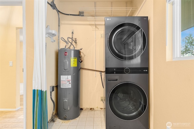 washroom with water heater, laundry area, and stacked washer / drying machine