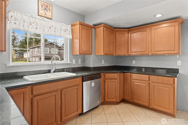 kitchen with dark countertops, dishwasher, light tile patterned floors, recessed lighting, and a sink