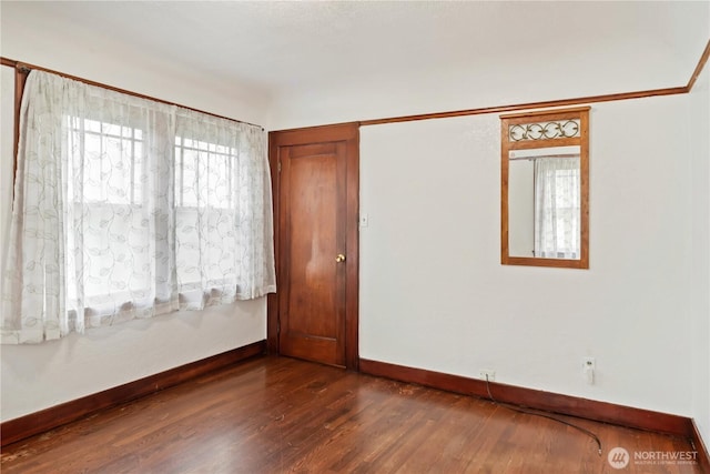 unfurnished room featuring dark wood finished floors and baseboards