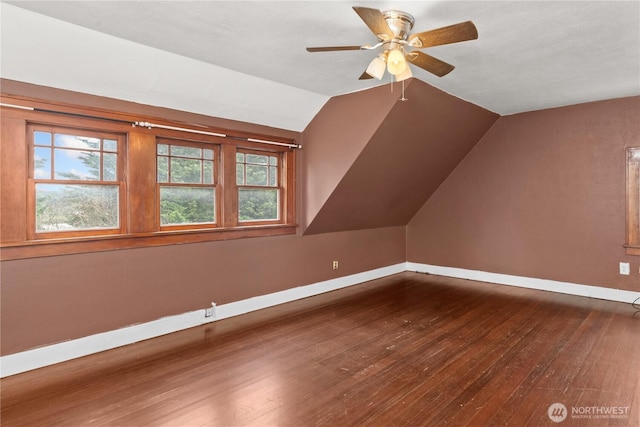 additional living space featuring hardwood / wood-style floors, lofted ceiling, plenty of natural light, and a ceiling fan