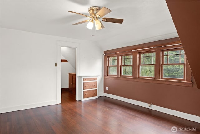 unfurnished room with ceiling fan, baseboards, lofted ceiling, and dark wood finished floors