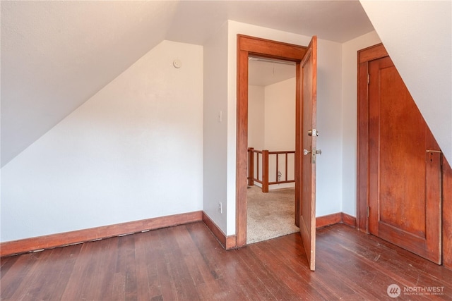 bonus room featuring dark wood-type flooring, baseboards, and lofted ceiling