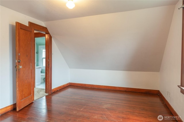 additional living space with vaulted ceiling, wood finished floors, and baseboards