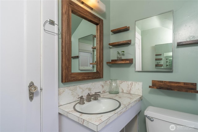 bathroom featuring toilet and vanity