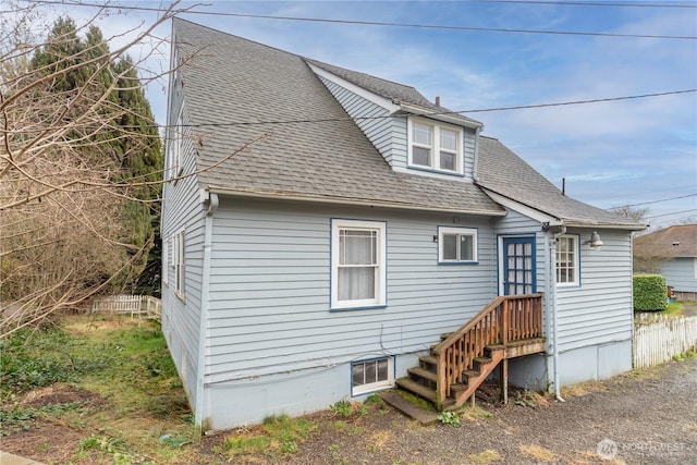 view of front of property with fence and roof with shingles