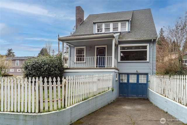 bungalow-style house with a porch, fence, an attached garage, a shingled roof, and a chimney