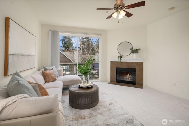 carpeted living room featuring a ceiling fan and a tiled fireplace