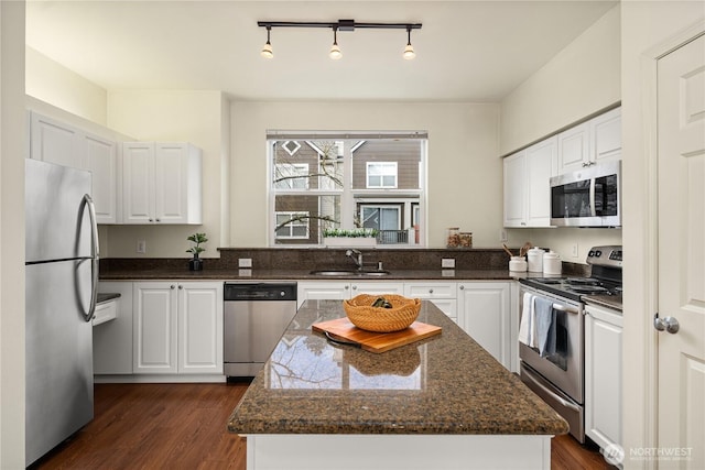 kitchen featuring white cabinetry, dark wood-type flooring, appliances with stainless steel finishes, and a sink