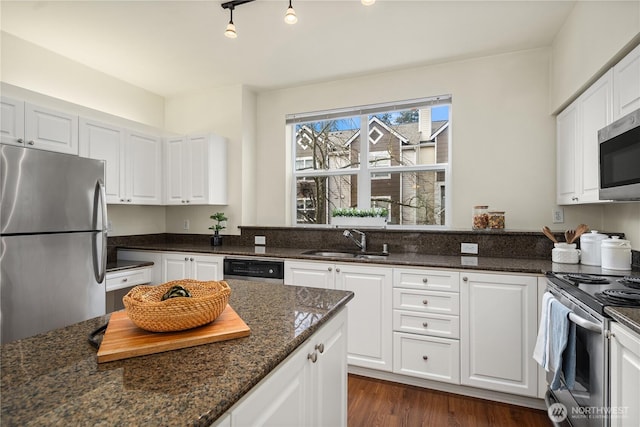 kitchen featuring dark wood-style flooring, white cabinets, appliances with stainless steel finishes, and a sink