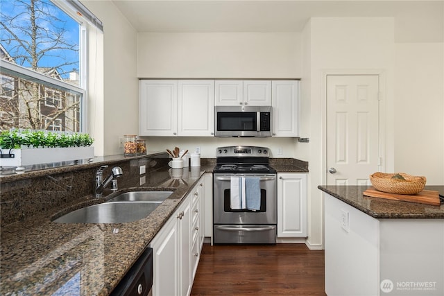 kitchen featuring white cabinets, dark wood-style floors, appliances with stainless steel finishes, and a sink