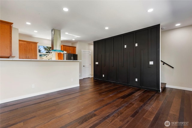 unfurnished living room with dark wood-style floors, recessed lighting, and baseboards