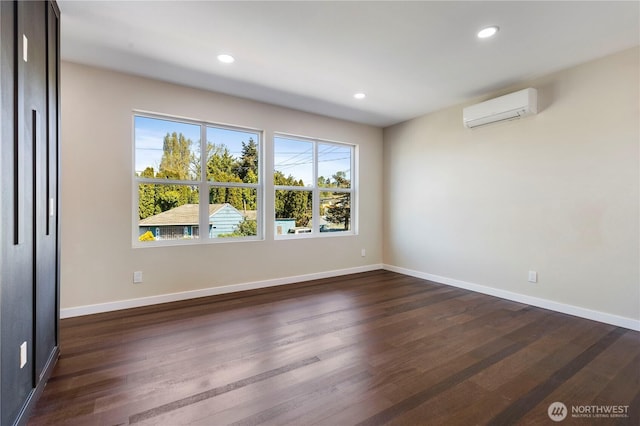 spare room featuring a wall mounted air conditioner, baseboards, recessed lighting, and dark wood-style flooring