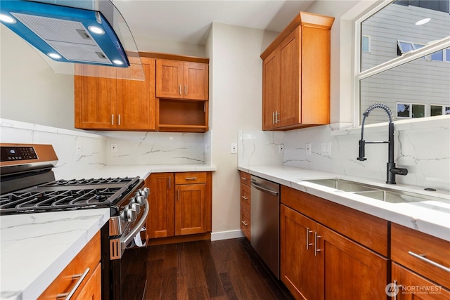 kitchen featuring a sink, light stone counters, range hood, appliances with stainless steel finishes, and dark wood-style flooring