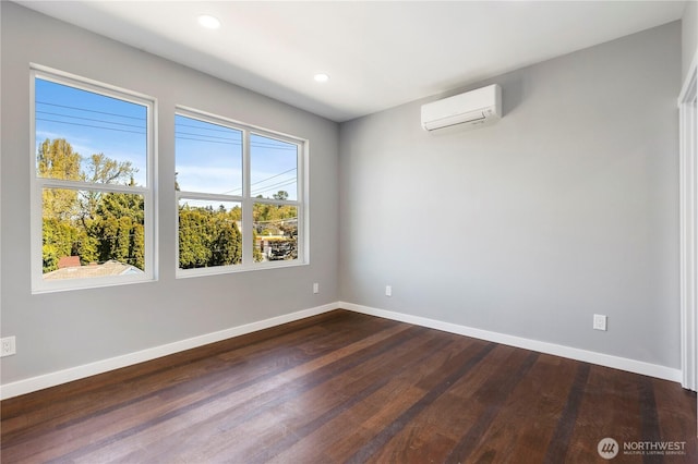 unfurnished room with baseboards, dark wood-type flooring, and a wall mounted AC