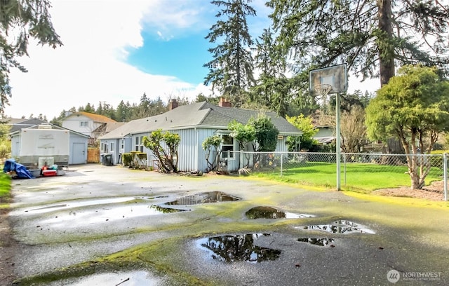 view of front of house with fence, driveway, a chimney, a front lawn, and a residential view