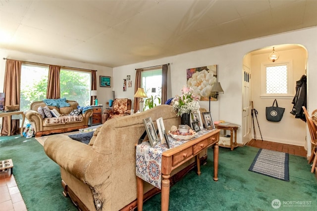 living area with baseboards, arched walkways, and carpet floors