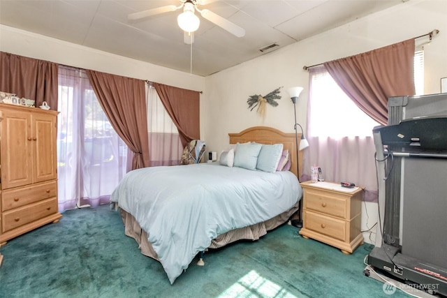 carpeted bedroom with multiple windows, a ceiling fan, and visible vents