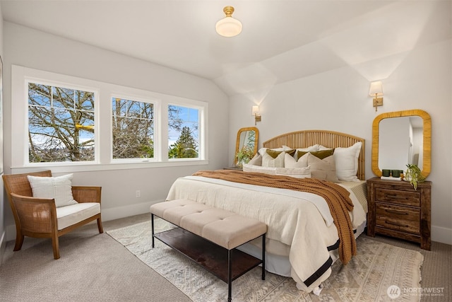 bedroom with baseboards, lofted ceiling, and carpet