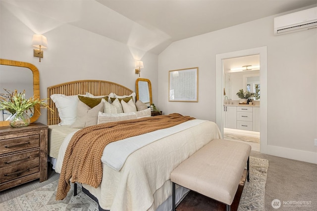 bedroom featuring baseboards, light colored carpet, a wall unit AC, vaulted ceiling, and ensuite bath