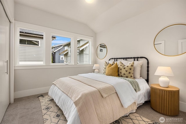 bedroom with vaulted ceiling, carpet, and baseboards