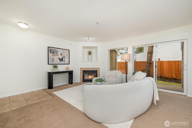 living area featuring a fireplace, baseboards, and carpet floors