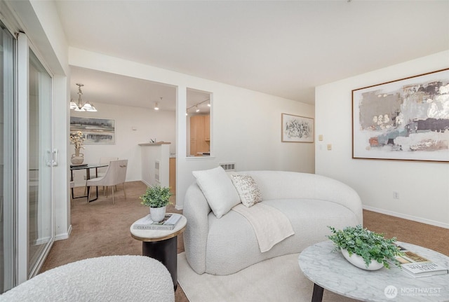 carpeted living area featuring baseboards, visible vents, and a chandelier