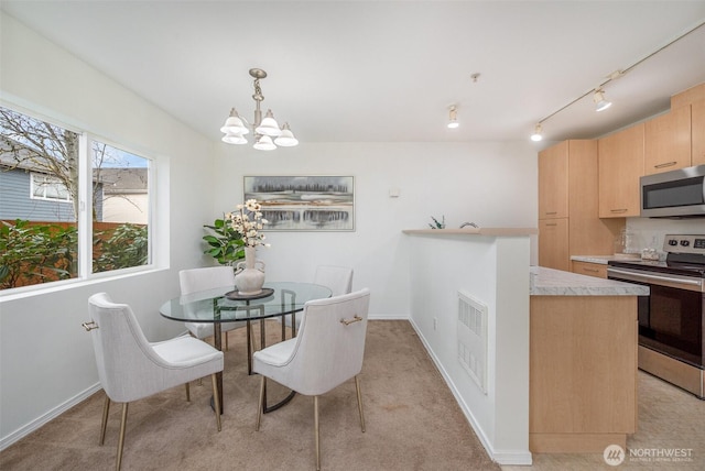 dining space with visible vents, baseboards, light colored carpet, and a chandelier