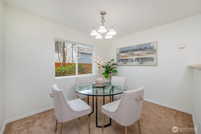 carpeted dining space with baseboards and an inviting chandelier