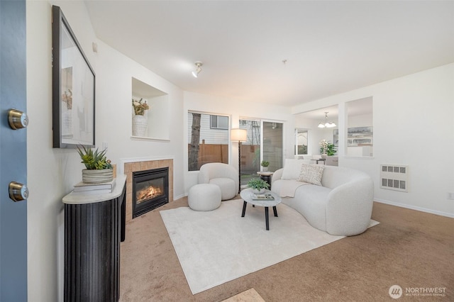 living area featuring visible vents, carpet floors, baseboards, an inviting chandelier, and a fireplace