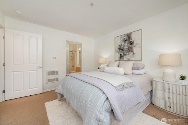 bedroom with visible vents, ensuite bathroom, and light carpet