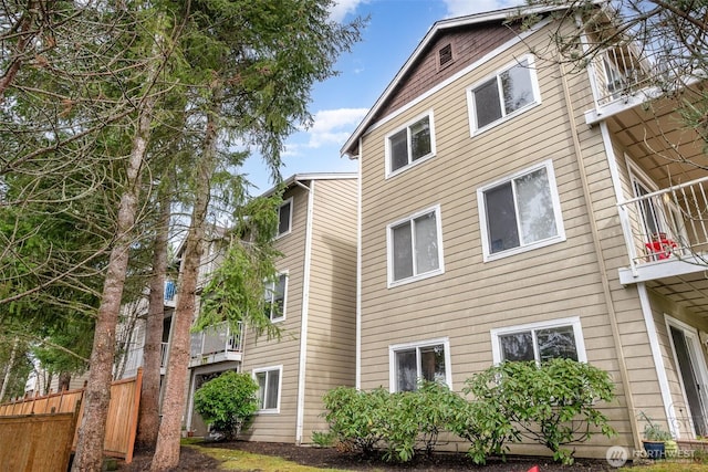 view of side of home featuring a balcony and fence